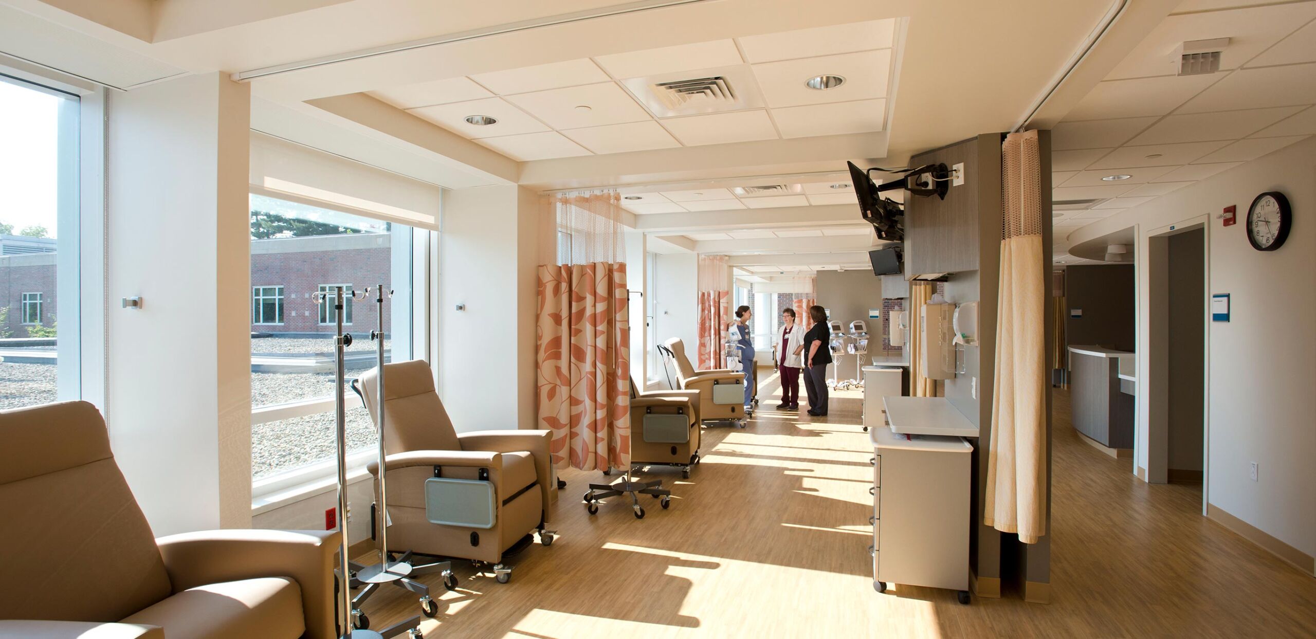 Cancer care providers confer in the infusion bay at the Mass General Cancer Center at Cooley Dickinson Hospital.