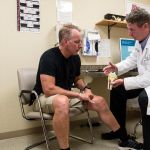 Chief of Orthopedic Surgery Jonathan Fallon, DO, MS, talks with a patient about knee replacement at Cooley Dickinson Medical Group Orthopedics & Sports Medicine, West Hatfield, MA 01088.