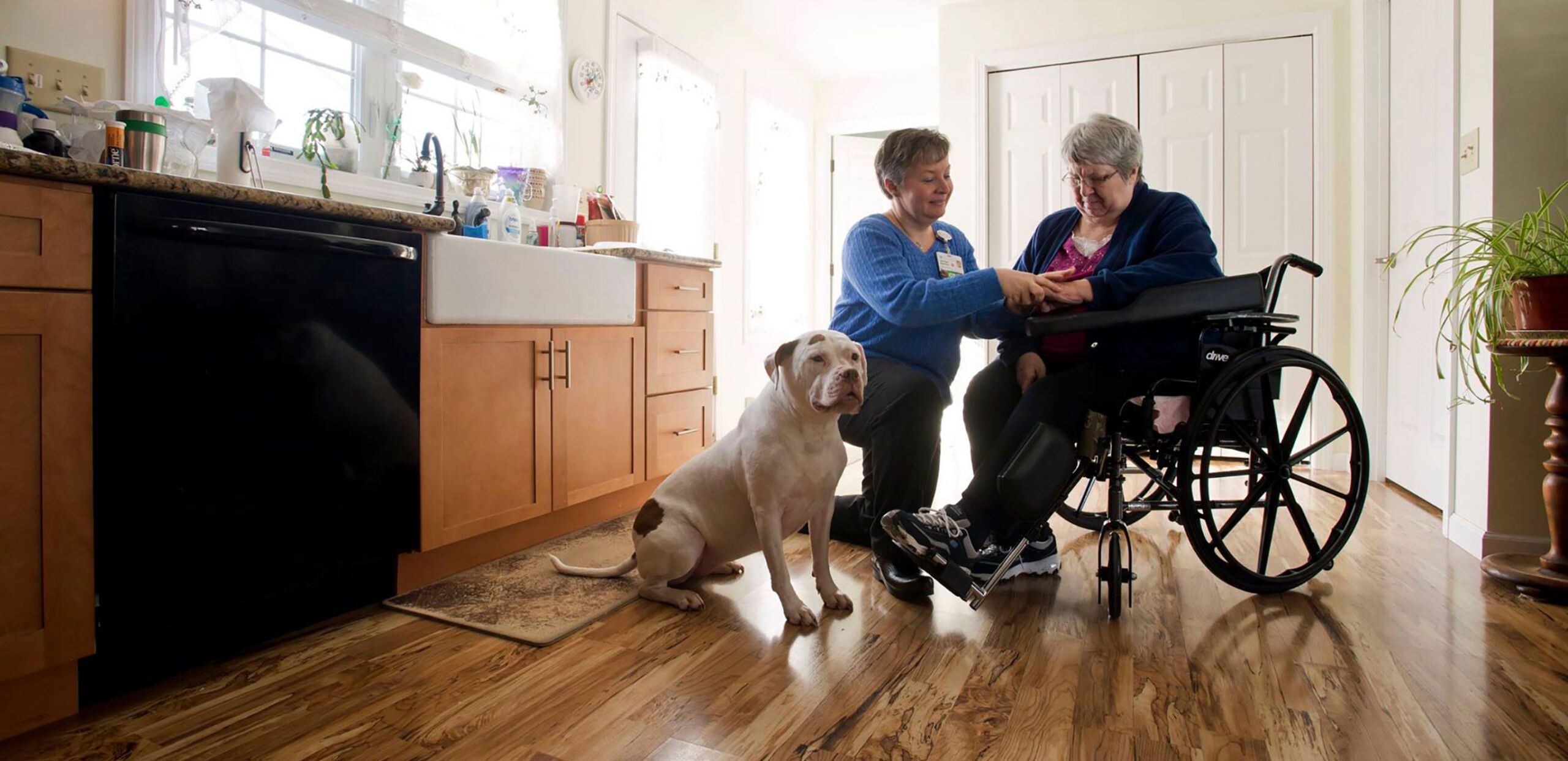 Visiting nurse talks with female patient in wheelchair in her home, Cooley Dickinson VNA & Hospice, Northampton, MA 01060.