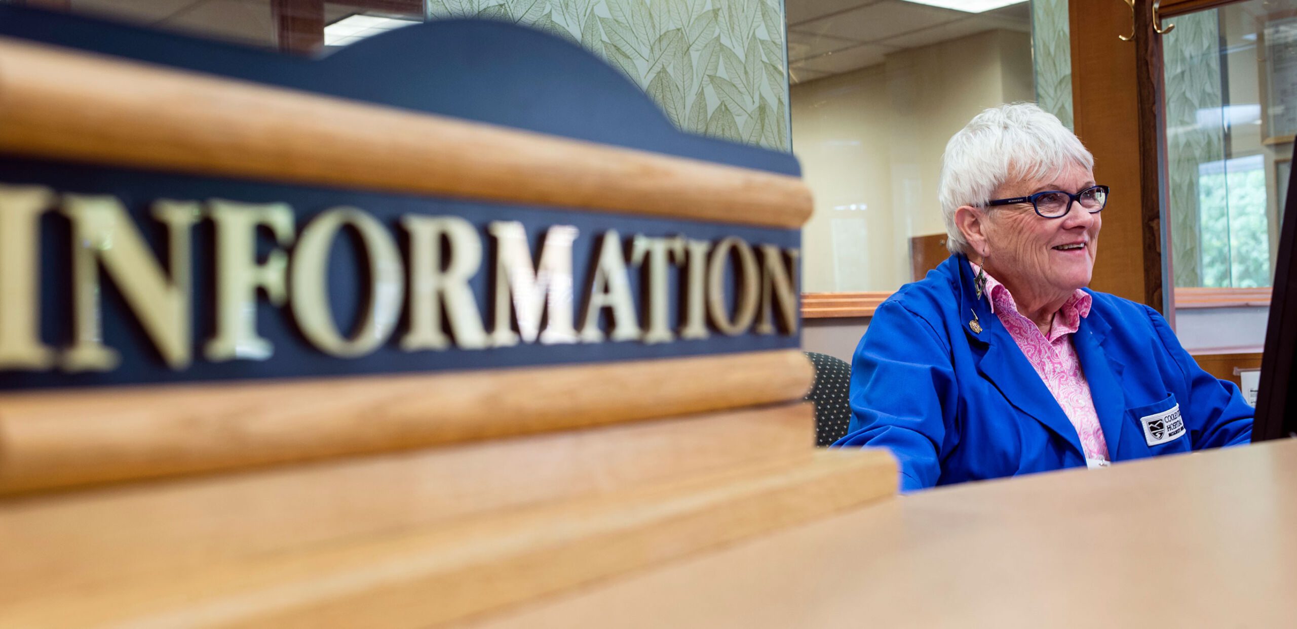 A volunteer greets visitors to the information desk at Cooley Dickinson Hospital, 30 Locust Street, Northampton, MA 01060.