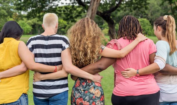 A diverse group of women with their arms around each other's shoulders