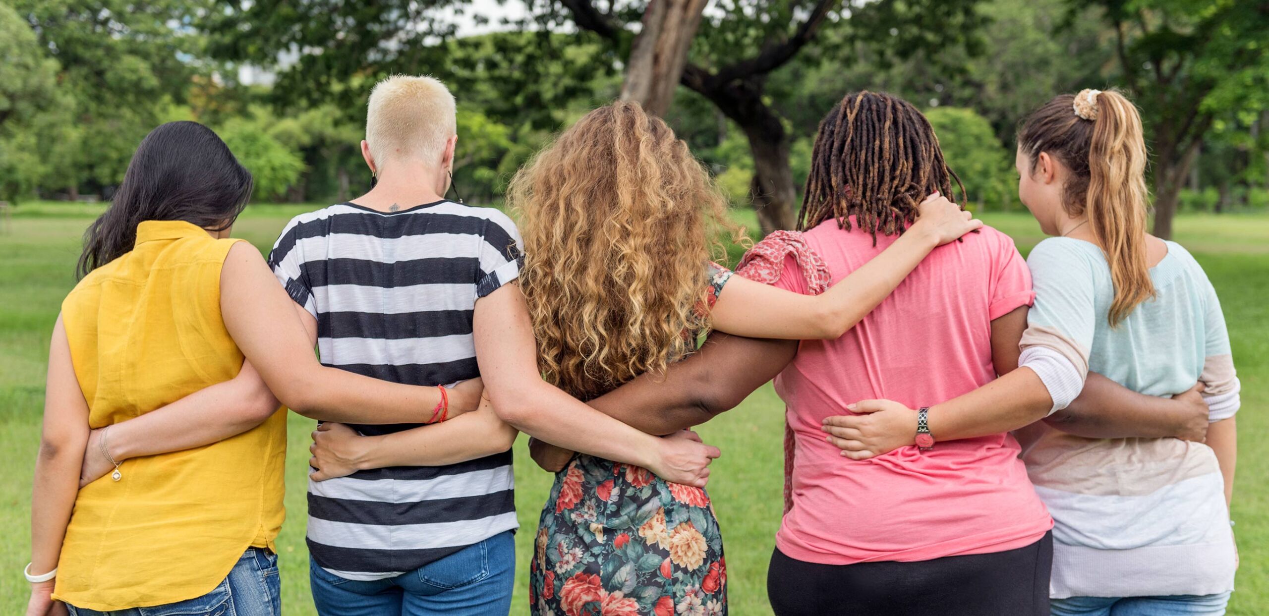 A diverse group of women with their arms around each other's shoulders