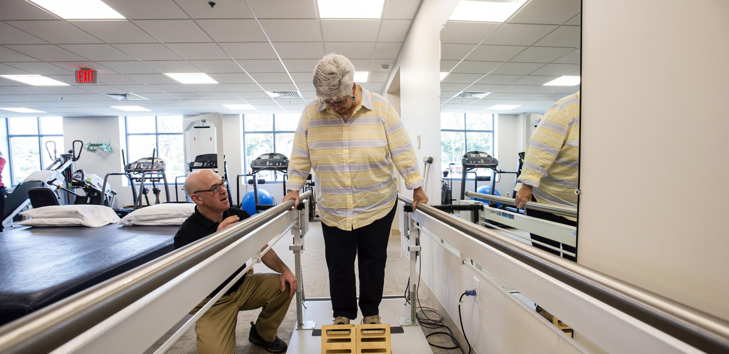 Male physical therapist helps female patient practice walking skills, Rehabilitation Services, Cooley Dickinson Medical Group, Northampton, MA 01060.