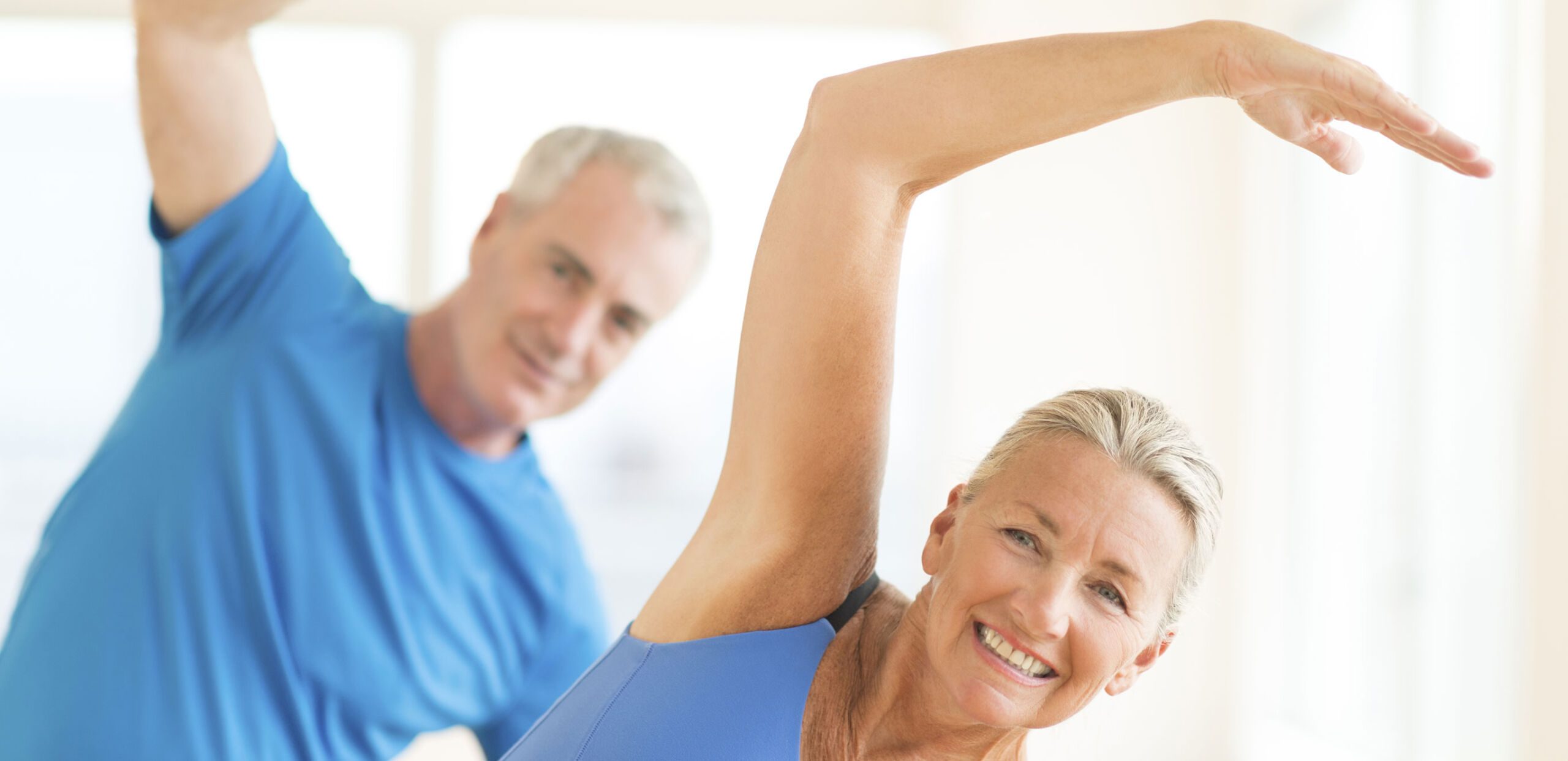 Middle-aged couple doing stretching exercises.