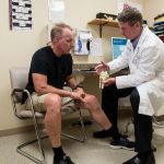 Chief of orthopedic surgery Jonathan Fallon, DO, consults with a male patient at Cooley Dickinson Medical Group Orthopedics and Sports Medicine, West Hatfield, MA 01088.