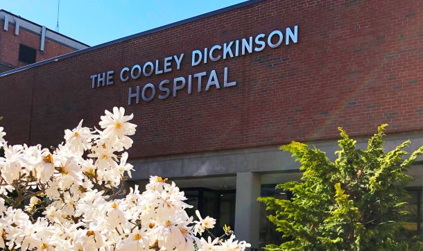 The front of Cooley Dickinson Hospital with spring flowers in view