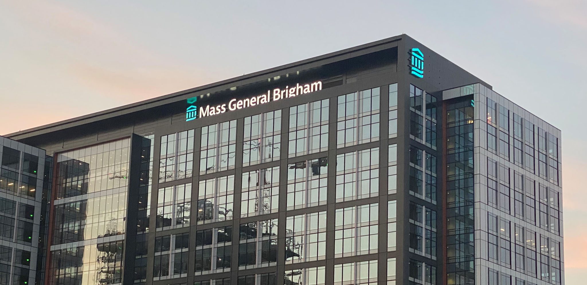 View of Mass General Brigham's main headquarters in Somerville, MA, at sunset.