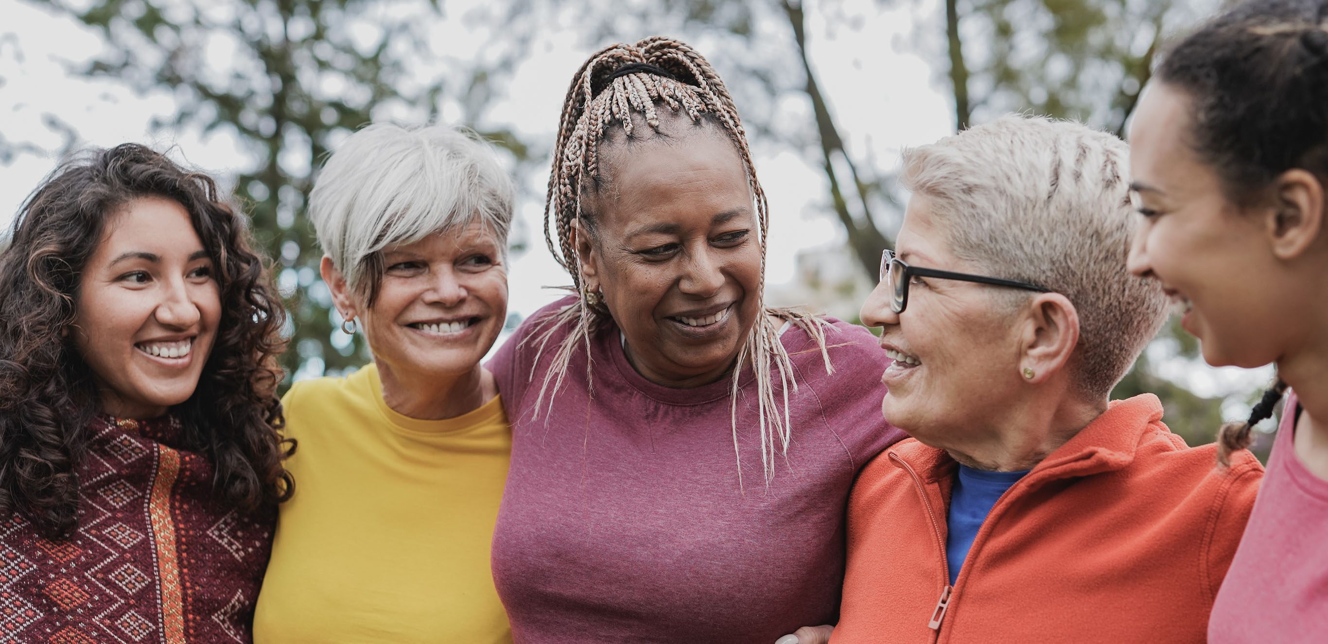 Group of senior women with their arms around each other.