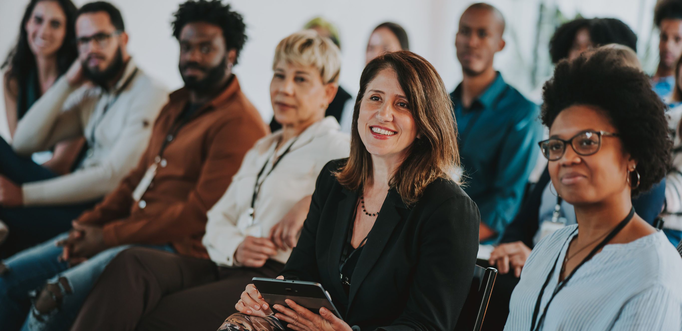 Group of people seated, listening to a speaker