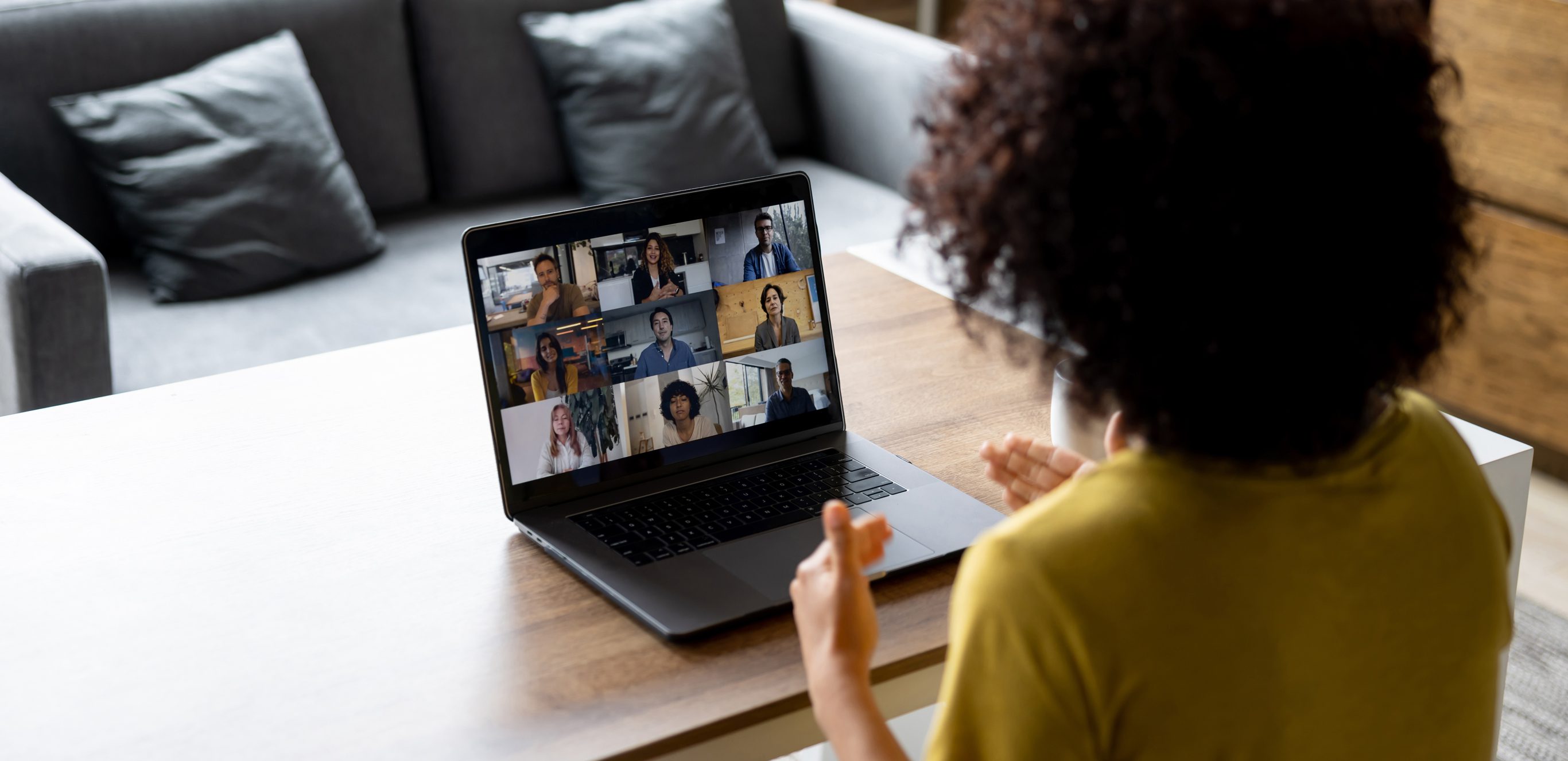 Over the shoulder view of woman on video conference call at home